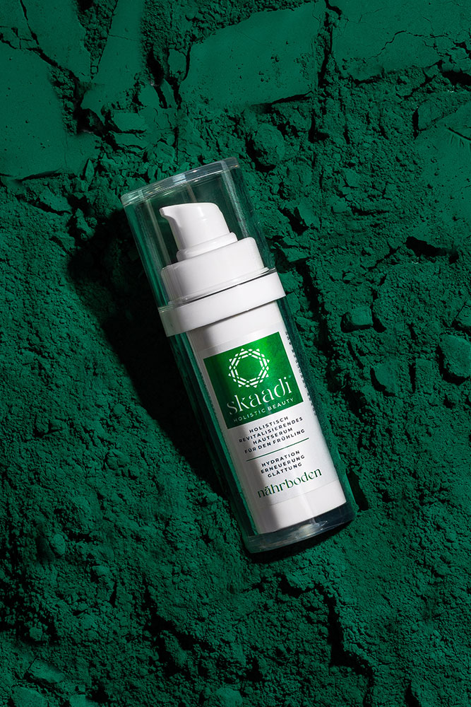 skaadi® Nährboden Elementra Frühlingsserum liegt auf dunkelgrünem pudrig-samtigen Untergrund