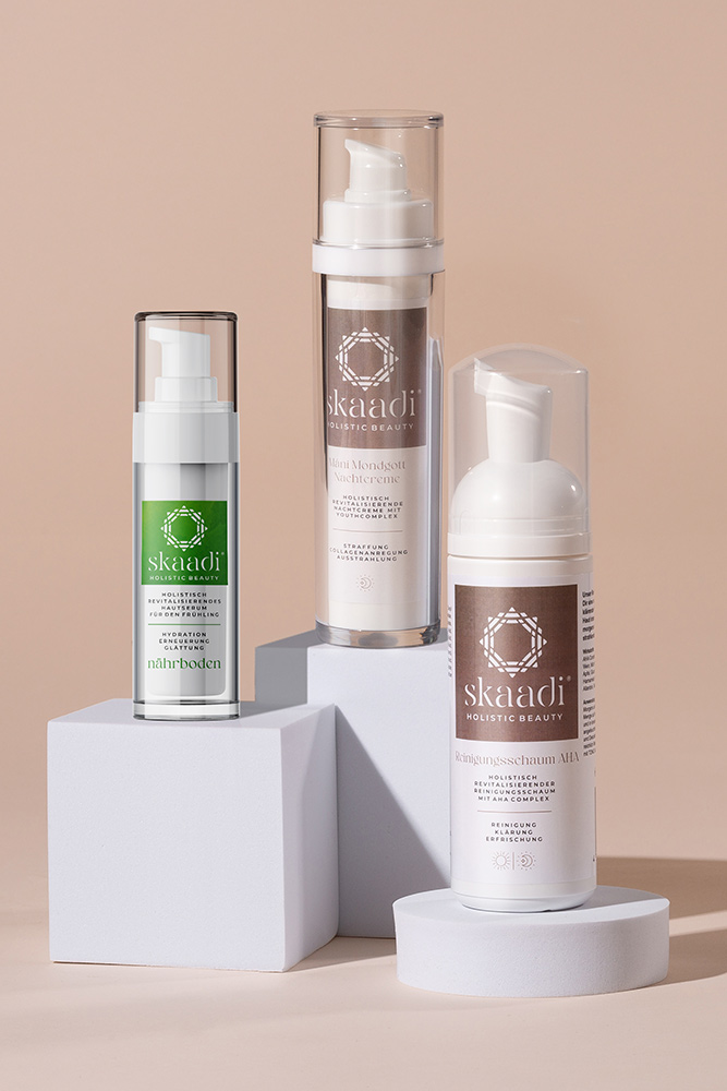 Alle im Repair Bundle enthaltene Produkte auf unterschiedlich großen weißen Quadraten und Kreisen platziert: Máni Mondgott Nachtcreme, nährboden Serum, Reinigungsschaum AHA